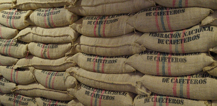 Piles of burlap bags filled with coffee beans. 