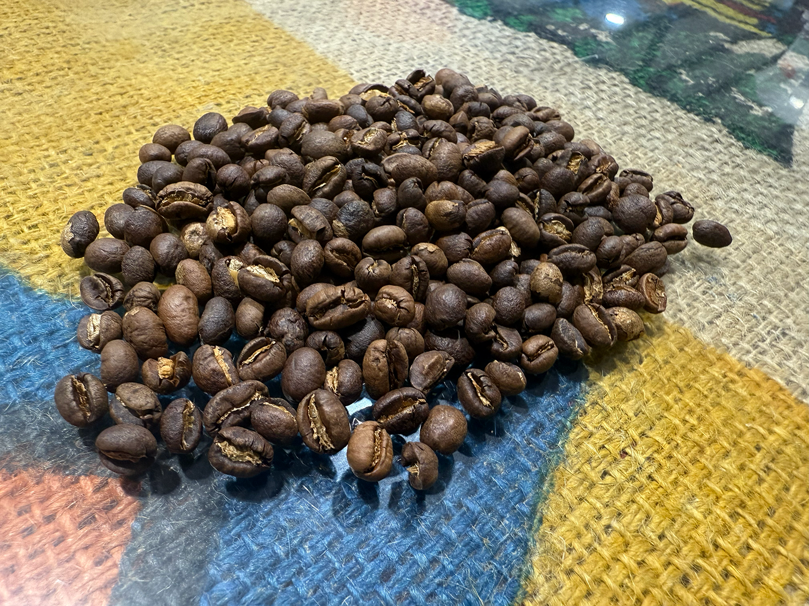 Medium-roasted Tanzania Peaberry coffee beans with even brown color and smooth matte surface.