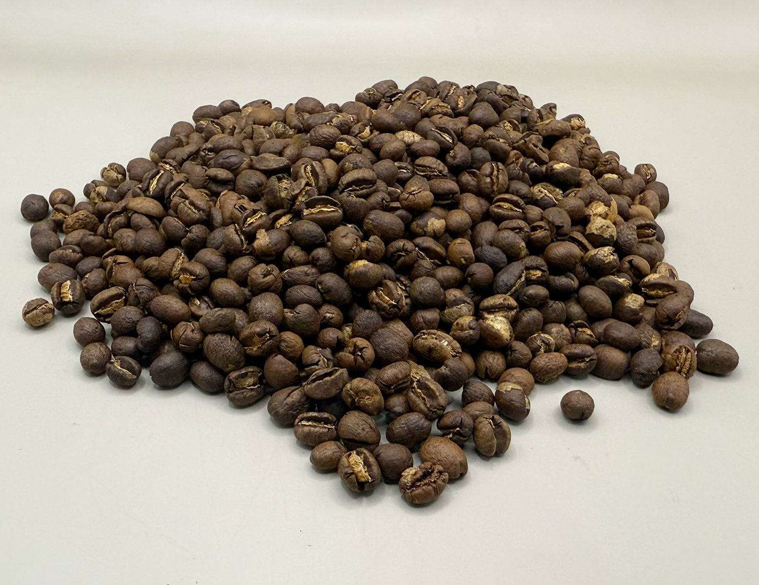 Medium-roasted Tanzania Peaberry coffee beans with even brown color and smooth matte surface.